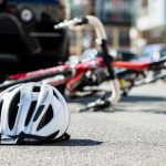 Cyclist’s helmet and bicycle lying in middle of road in front motor vehicle
